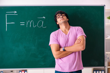 Young male physic standing in front of the green board