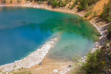 Naklejka na ściany i meble Open pit mining gold quarry with blue water