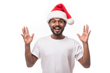 Young indian pretty man with santa hat surprised isolated on white background