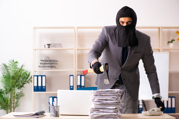 Male gangster stealing information from the office 