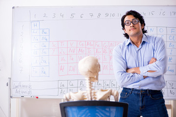 Young male chemist teacher and student skeleton 