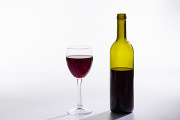 Glass and bottle with red wine on white background