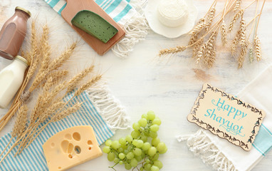 top view photo of dairy products over white wooden background. Symbols of jewish holiday - Shavuot