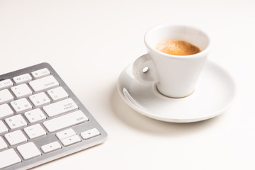 A close up view of arranged computer keyboard,cup of coffee on white table