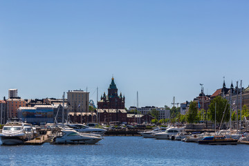 Fototapeta premium Yachts in the port and the cityscape of Helsinki in the sunny summer day