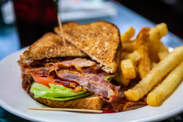 A classic bacon lettuce and tomato sandwich with french fries