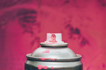 Pink balloon Aerosol paint close up on a pink background behind.