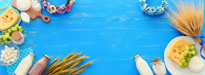 top view photo of dairy products over blue wooden background. Symbols of jewish holiday - Shavuot