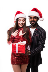 Happy asian couple of lovers, in Santa Claus hats, celebrates the New Year, with Christmas gifts on a white background.