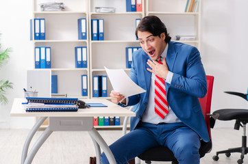 Young happy male employee in the office 