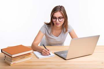 Study, education and people concept - young female nerd is learning exercises using laptop