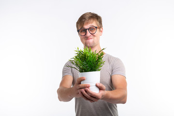 Fun, joke, nerd and geek concept - Funny man holding a flower in a pot over white background