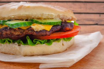 fresh flavored cheeseburger with juicy cutlet, cucumbers, tomato and lettuce