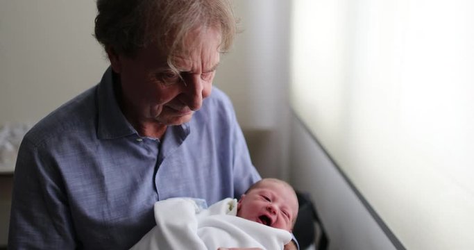 Newborn baby infant being held by grand-father