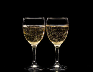 Two crystal wine glasses with a drink, falling ice and splashes