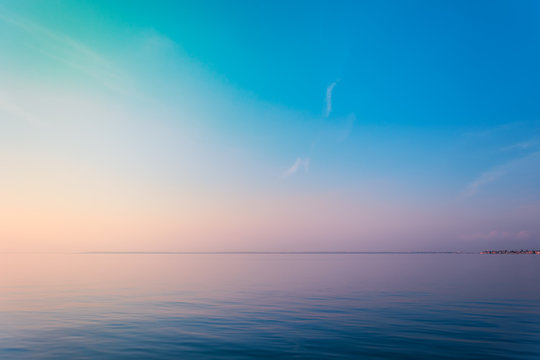 Horizontal sea line in the evening sunlight over sky background. Blue hour sunset. Summer adventure or vacation concept. Copy space.
