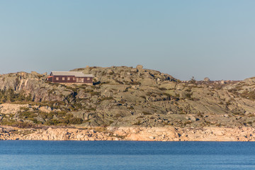 View of dam Marques da Silva and long lagoon , lagoa comprida, granitic rock geology on banks with a building