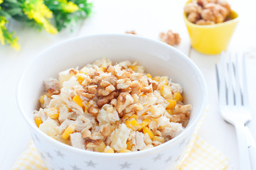 Salad with corn, chicken and pineapples in a white bowl, horizontal
