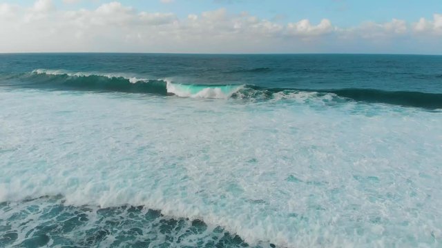 aerial footage of breaking waves in the morning at Melasti Beach in Uluwatu, Bali