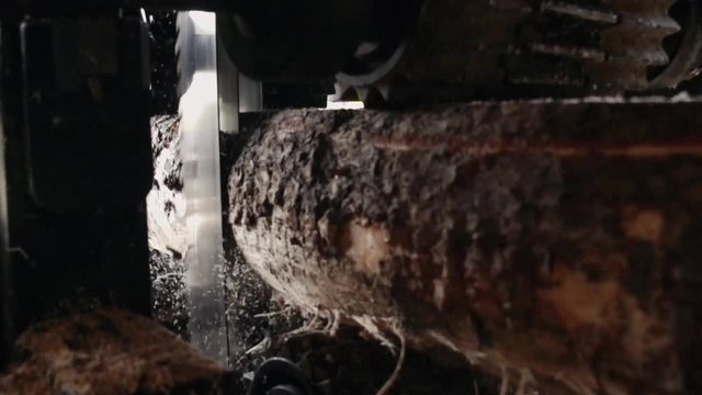 production of wooden lumber and planks. A sawmill blade saws a log into planks. sawdust flying slow motion