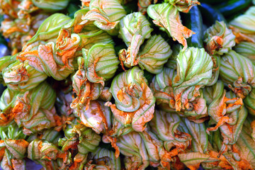 Zucchini flower blossoms in a crate at an Italian farmers market