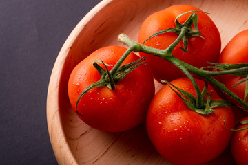 Tomato vegetables on wooden plate close up angle view