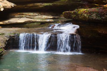 Obraz premium Waterfall outdoors with a stream and rocks