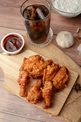 Hot and spicy Korean barbeque fried chicken on wood cutting board