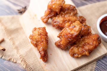Hot and spicy Korean barbeque fried chicken on wood cutting board