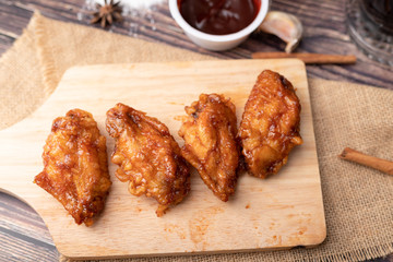 Hot and spicy Korean barbeque fried chicken on wood cutting board