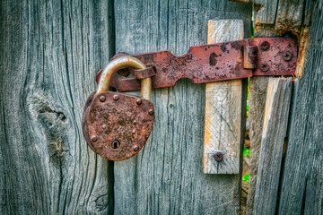 Old vintage metal door lock on wooden door background texture