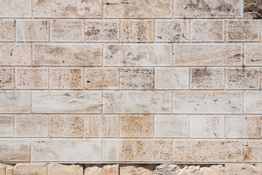 Seamless texture of antique stone wall. Greek masonry white antique stones.