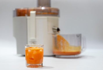 Modern electric juicer  various fruit and glass of freshly made juice  healthy lifestyle concept