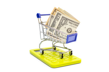 Shopping cart with money and calculator on white.