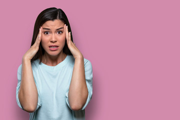 Anxious female worried and concerned, having inner conflict, stress, anxiety, isolated on pink background, copy space - obrazy, fototapety, plakaty