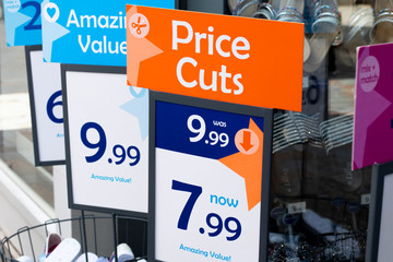 price cuts and amazing value signs outside budget shoe shop