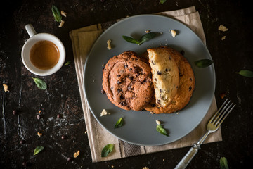 Coffee glass and milk with chocolate chip cookie on dark stone concrete table background. Morning...