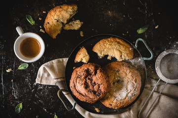 Cup of coffee with chocolate chip cookies in a vintage pan, black table background. Morning Breakfast Concept. Copy space, top view - Image