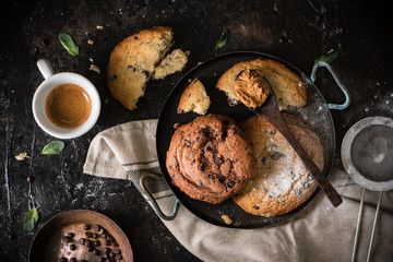 Cup of coffee with chocolate chip cookies in a vintage pan, black table background. Morning Breakfast Concept. Copy space, top view - Image