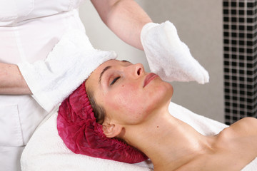 The cosmetologist removes the rejuvenation product from the patient’s face. The procedure in the cosmetology clinic. The concept of beauty and health. Close-up of a girl's face.