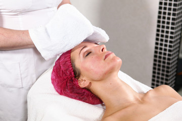 The cosmetologist removes the rejuvenation product from the patient&rsquo;s face. The procedure in the cosmetology clinic. The concept of beauty and health. Close-up of a girl's face.