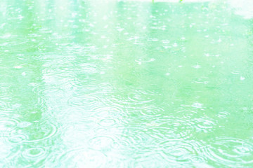 Fototapeta na wymiar Raindrops on a puddle. Soft blue tone. Beautiful background.