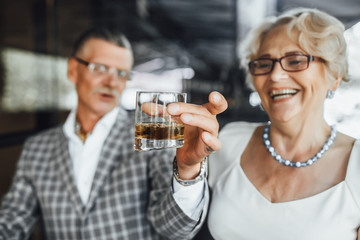 Focus at glass with whiskey .Seniors couple