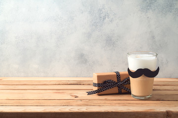 Happy Father's day concept with latte macchiato coffee and gift box over wooden background