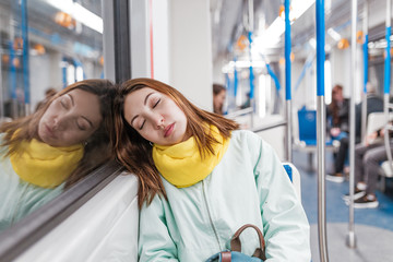 The girl suffering from insomnia sleeps or taking a nap in the subway while tired goes home from...