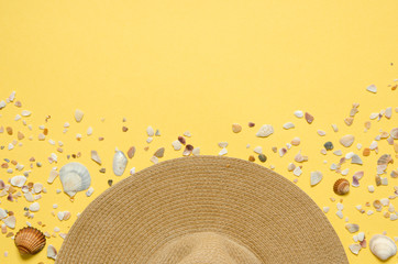 Fototapeta na wymiar Summer vacation concept flat lay. Hat and seashells on yellow background. Copy spase. - Image
