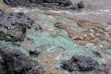 pebble stones on the sea beach, the rolling waves of the sea with foam
