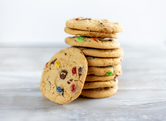 Stack of chocolate chip candy cookies on light background