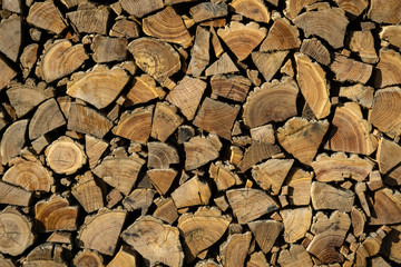 Neatly stacked firewood.  Background of dry chopped logs