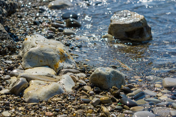 pebble stones on the sea beach, the rolling waves of the sea with foam